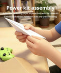 RC Paper Airplane Kit With Gyro Stabilizer assembly with child folding paper and green remote in the background.