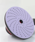 Close-up of Cubitron II Hookit Clean Sanding Abrasive Disc 31465 For Automotive Sanding 3 Inch 500 Plus Grit, showing multi-hole pattern.