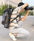 Photographer using a DSLR Waterproof Camera Backpack With Large Capacity Anti Theft Design For Pro Photogs And Photographers, crouching outdoors.