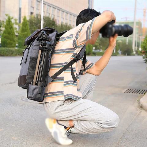 Photographer using a DSLR Waterproof Camera Backpack With Large Capacity Anti Theft Design For Pro Photogs And Photographers, crouching outdoors.