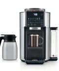 Front view of TrueBrew Drip Coffee Maker With Built-In Grinder And Bean Extract Technology, Stainless Steel, next to carafe.