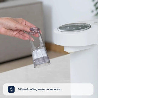 Zero Drama Instant Boiling Water Dispenser And Rapid Chill Formula Preparation Machine for baby bottle prep, showing a user holding water container.