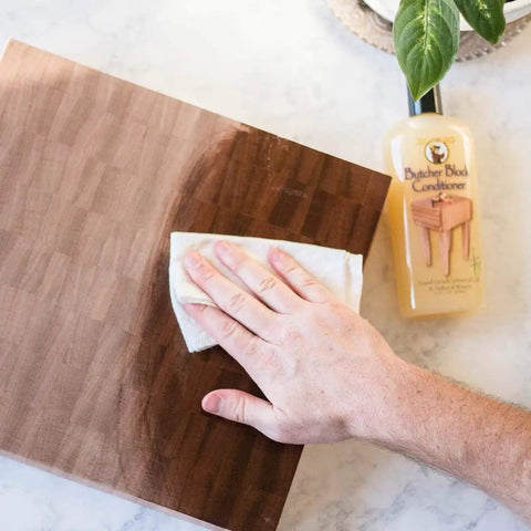Applying Butcher Block Conditioner 12 Ounce 5 Pack for Wood Countertops and Cutting Boards, Food Safe Oil Treatment on surface.