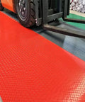 Heavy Duty Insulating Rubber Electrical Safety Mat Built Like A Tank For Real Deal High Voltage Protection And Slip Resistant Flooring That Keeps Every Tradesman Locked In All Day showing red mat under forklift wheels.