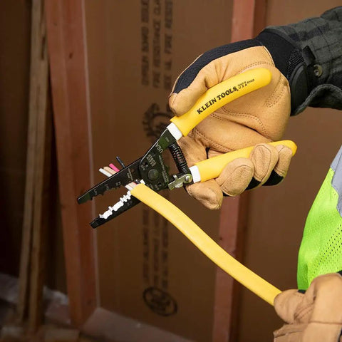 Person using Dual NM Cable Stripper And Cutter For 12 And 14 AWG Wire, Strips 12/2 And 14/2 Outer Jacket, in construction setting