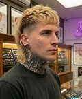 Person in a jewelry shop with Dermal Top Multi Pack 14G 16G Implant Grade Titanium Surface Piercing Jewelry Set displayed in background.