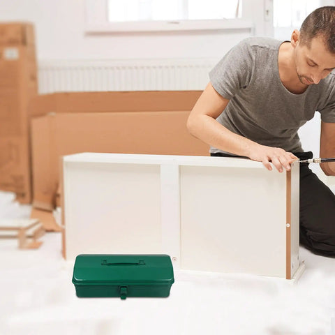 Big Boy Green Metal Toolbox with Rugged Carry Handle and Secure Latch Perfect for Garage Organization and Truck Bed Runs Features Plenty of Room to Sort Out Hammer Screwdriver Pliers Drill and More Making Home Repairs and Auto Fixes a Breeze, positioned in the foreground as a man assembles furniture.