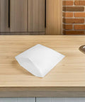 Single white EPE foam packing pouch on wooden countertop, part of 25 pack, shockproof cushion bag for fragile dishes and glassware.