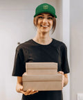 Woman wearing Green Women's Trucker Hats Bundle For Everyday Style And Dope Cap Game holding gift boxes