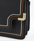 Close-up of 12 Pack Slick Metal Handbag Corner Protectors With Shiny Electroplated Finish For Purses, showing decorative stitching and edges.