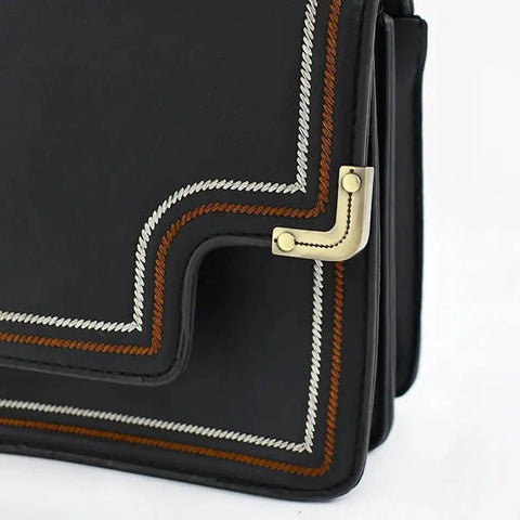 Close-up of 12 Pack Slick Metal Handbag Corner Protectors With Shiny Electroplated Finish For Purses, showing decorative stitching and edges.