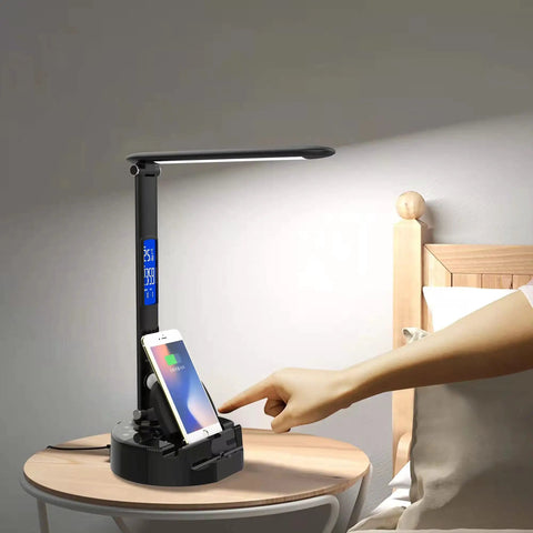 Smart LED Desk Lamp With Wireless Charger And USB Port, Built-In Bluetooth Speaker on bedside table charging phone.