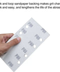 Person holding P80 hook and loop sandpaper sheet with holes for 1/3 sheet sander, part of the versatile grit set for woodworking and metalworking projects.