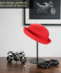 Sturdy Metal Hat Stand For Desk Or Shelf, Hat Display Holder with a red hat, set on a wooden surface next to a toy motorcycle.