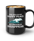 Black ceramic coffee mug with 'The Sea is My Happy Place, My Troubles Disappear' text, ideal for nautical coffee lovers.