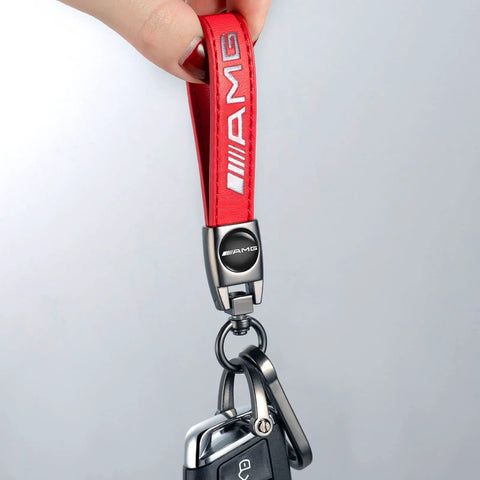 Premium Genuine Leather Keychain For Mercedes Benz Amg with red strap and zinc alloy swivel clip held up for display.