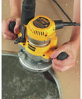 Beefy 2 1/4 Hp Plunge Router Kit with sturdy fixed base used for precise contour routing on hardwood surface.