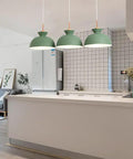Three 11inch Wood Pendant Lights in matte green hanging over a modern kitchen island, stylish Nordic decor for farmhouse.