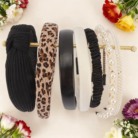 Snag These 7 Pack Of Ultra Comfy Headbands For Women Mixing Neutral Solid Knotted Padded Styles With Pearl Accents Soft Durable Daily Wear Essentials To Upgrade Any Fit displayed on a wooden holder.