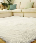 Plush white shag area rug with beige sectional sofa and green cushions in a bright living room.