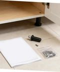 DIY Friendly Spring Loaded Cabinet Door Repair Pins Kit with parts laid out on the floor next to an open cabinet door