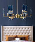 Straight Up Gorgeous Copper And K9 Crystal Ceiling Pendant Light Delivers A Warm Glow Perfect For Modern Living Rooms And Bedrooms Adds That Sleek Minimalist Vibe You Gonna Absolutely Love Every Day in gold and blue hues above a tufted bed.