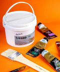 Premium Gesso Universal Primer 64oz for canvas, wood, paper and more with paint tubes and brushes on orange background