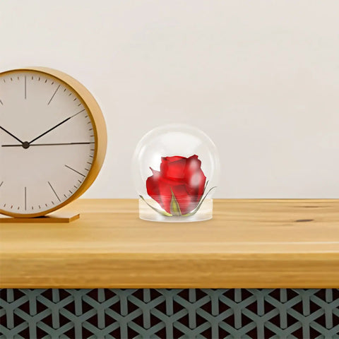 Clear 4 Inch Snow Globe Kit with fillable red rose inside, placed on wooden table next to clock for DIY decor and gift ideas.