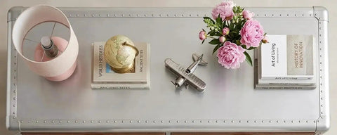Knockout Aviator Sideboard Cabinet Drops That Aero Industrial Heat With Wraparound Weathered Brown Leather Riveted Silver Trim And Massive Storage Building A Solid 54 Inch Credenza Console Table For Any Cool Living Space with lamp, globe, and flowers on top.