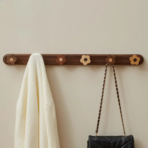 Dang Cute Flower Peg Wall Mount Coat Rack For Kids Crafted From Solid Walnut Wood Storage Perfect For Quick Hanging Heavy Backpacks Coats And Towels In Nurseries Without Any Setup Frustration mounted on wall with cream scarf and black purse.