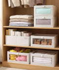 4 Pcs Foldable Closet Storage Bins With Clear Window For Slick Organization And No Sweat Folding To Keep Your Wardrobe Tidy And Make Room Organization A Total Breeze on a wooden shelf with folded clothes and toys.