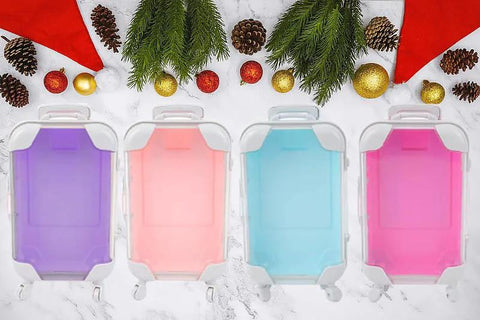 Mini suitcase favor boxes with wheels in four colors (purple, peach, light blue, pink) for gifts