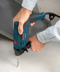 Person using 120 Volt One Half Inch Hammer Drill With 7 Amp Motor Lightweight Workhorse Single-Speed 360 Degree Auxiliary Handle on concrete