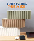 Three Huge Desk Cable Management Boxes for Home Office stacked in different colors next to a laptop and phone.