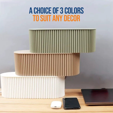 Three Huge Desk Cable Management Boxes for Home Office stacked in different colors next to a laptop and phone.