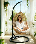 Woman sitting in egg chair on Beefy Heavy Duty Hammock Chair Stand Steel Frame Supports Up To 330 Lbs For Egg Chair Or Swing Chair Indoor Outdoor