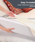 Hand placing Rock Solid Toddler Bed Guard Rails And Foam Bumpers for Kid Safety under fitted sheet, grey foam pad.