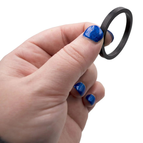 Water heater element gasket, black rubber, close-up held between fingers