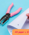 Mini One Quarter Inch Circle Hole Punch With Pink Soft Grip shown punching a 1/4 inch hole in paper, suitable for crafting and scrapbooking.