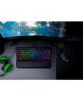 Classic Black Tenkeyless Mechanical Gaming Keyboard With Tactile Orange Switches And Smooth RGB Backlighting on a desk with a gaming monitor.