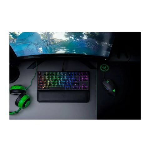 Classic Black Tenkeyless Mechanical Gaming Keyboard With Tactile Orange Switches And Smooth RGB Backlighting on a desk with a gaming monitor.