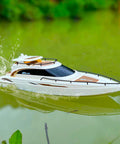 Dope Modern Yacht RC Boat One To Twenty Eight Scale with 2.4GHz Remote cruising on a pond with glossy ABS hull visible