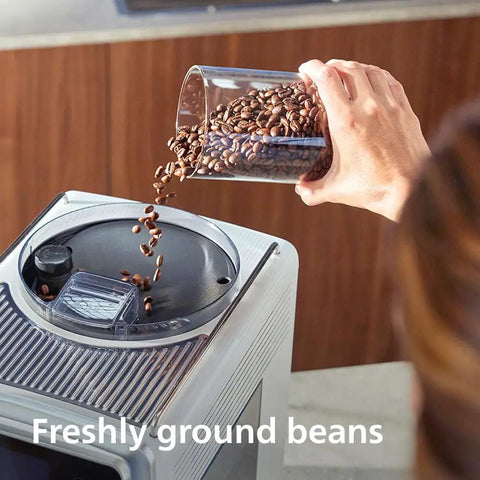 Hand pouring freshly ground beans into Super Automatic Espresso Maker With Smooth LatteGo Pro Milk Frother Brewextract Grind Boost.