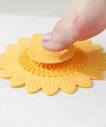 Floor Drain Plug Shower Bathtubs Drain Covers, Flower, White with a finger pressing down on the suction part on a wet surface.