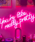 "You're like really pretty" pink neon sign on wall, 25.5x11.8 in, flexible silicone, for indoor bedroom decor and chill vibe parties.