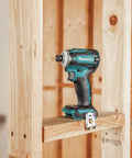 XDT16Z 18V LXT Brushless Cordless Impact Driver with Quick Shift Mode on wooden frame, showcasing compact design.