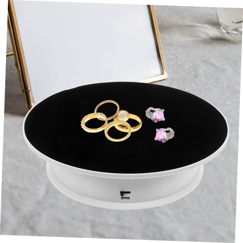 Rotating Electric Turntable Display Stand With Smooth Motorized Motion showcasing gold and silver rings on a black velvet top.
