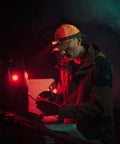 Man using Vizz Headlamp 550 Lumen Dimmable LED With IPX7 Waterproof Seal, red LED beam, outdoors at night