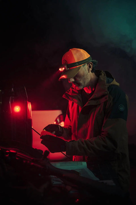 Man using Vizz Headlamp 550 Lumen Dimmable LED With IPX7 Waterproof Seal, red LED beam, outdoors at night