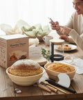 Ultimate Sourdough Starter Kit With Banneton Proofing Baskets 14 Piece Bread Making Set on wooden table with fresh bread
